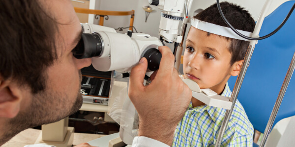 Young boy sitting in eye examination machine