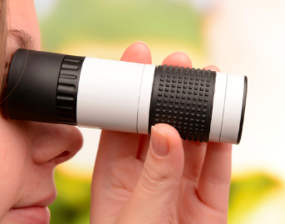 woman holding binocular to eye to see